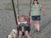 Two kids in a swing.